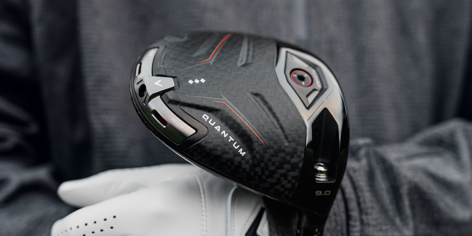 En golfspelare med vit handske håller ett svart golfklubbs-huvud med texten "QUANTUM" och "NEUTRAL" mot en mörk bakgrund.