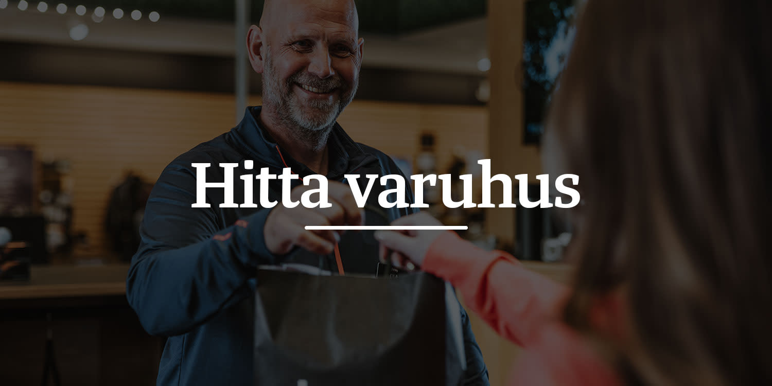 Leende man lämnar över en shoppingpåse till en kund i butiksmiljö, texten "Hitta varuhus" syns i mitten.