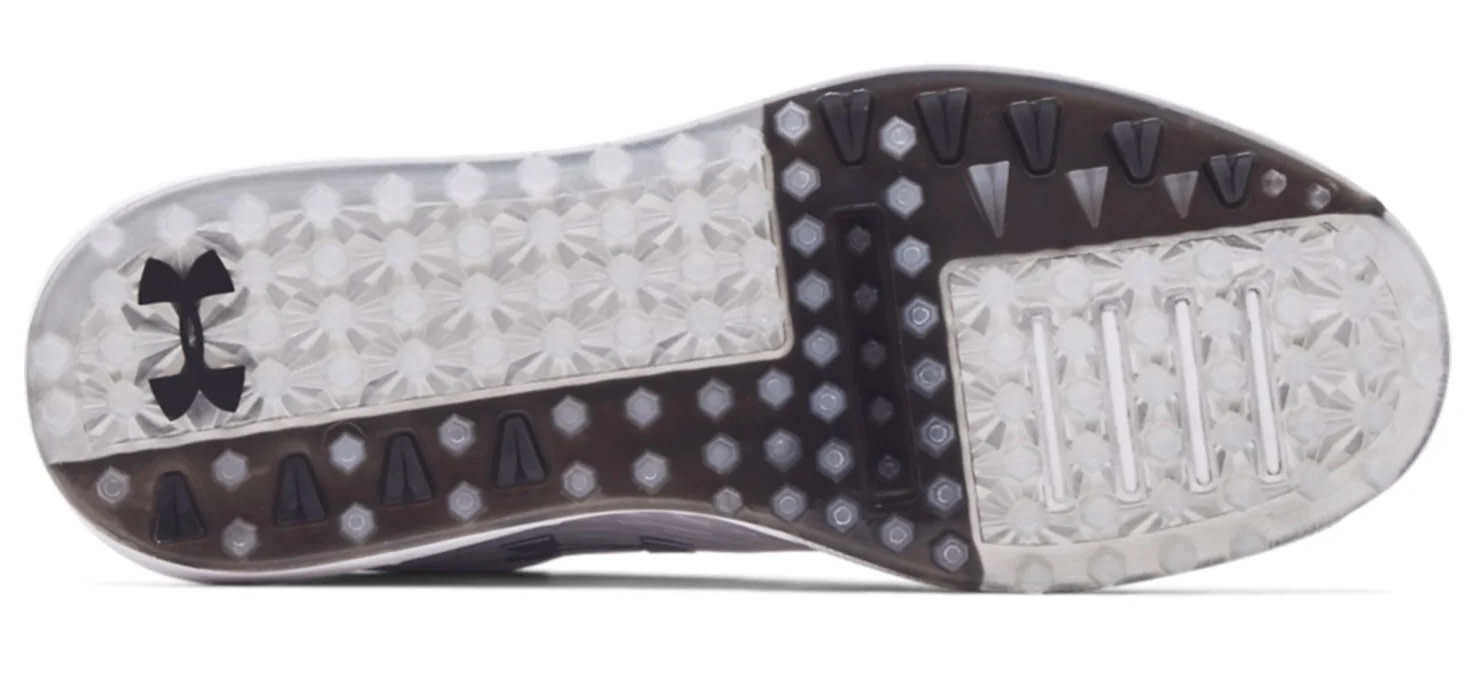 Undersida av en sportskosula med mönstrad gummiyta, svarta detaljer och Under Armour-logotyp på vänster sida.