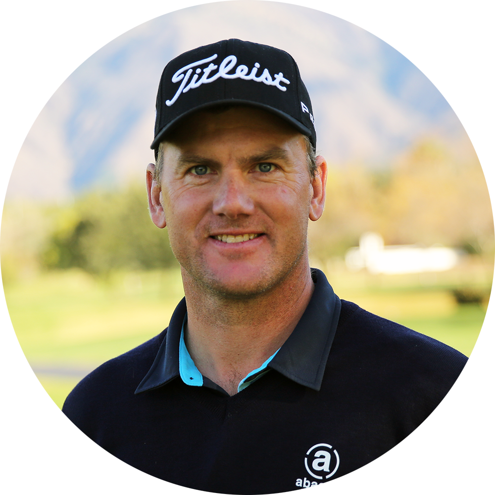 Man med svart Titleist-keps och mörk tröja står utomhus på en golfbana med suddig bakgrund.