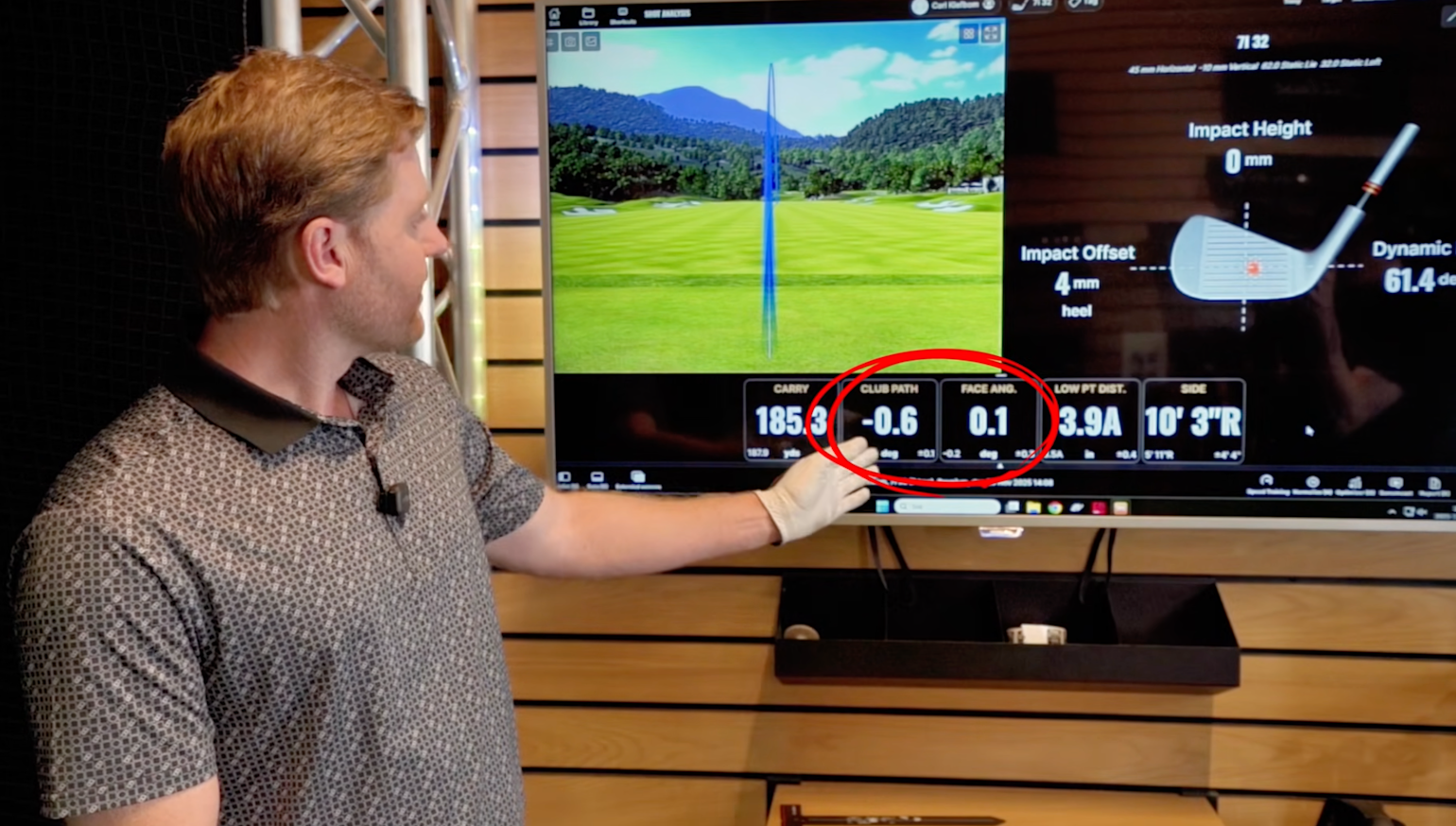 A man wearing a golf glove points at a screen displaying golf data, with the numbers "CLUB PATH -0.6" and "FACE ANG. 0.1" circled in red.